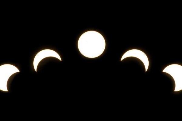 A minimalist depiction of solar eclipse phases captured in a crescent pattern on a dark background. ग्रहण क्या होता है