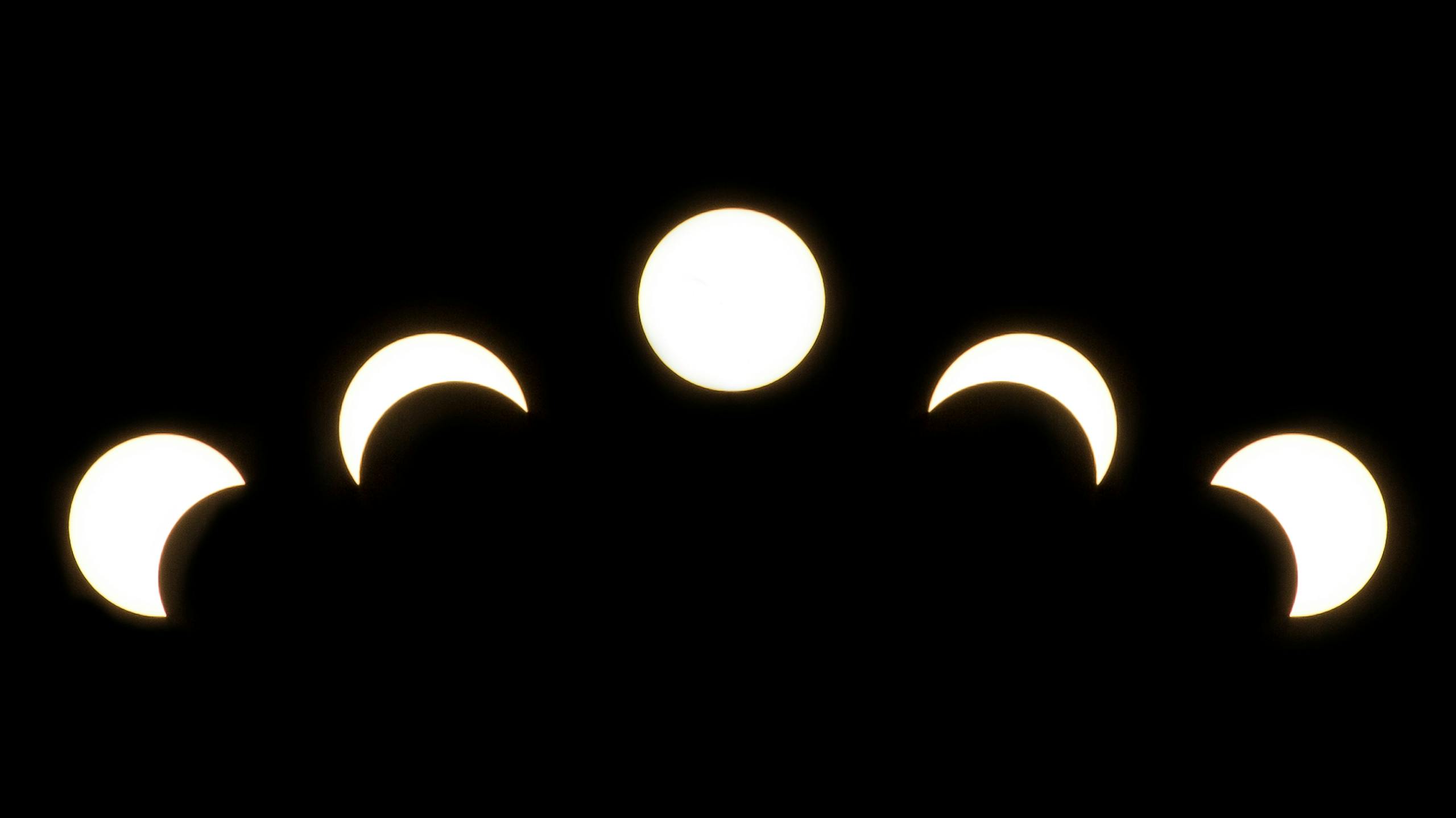 A minimalist depiction of solar eclipse phases captured in a crescent pattern on a dark background. ग्रहण क्या होता है