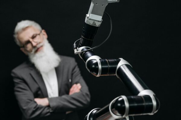 A robotic arm versus a thoughtful man in a strategic chess game indoors.