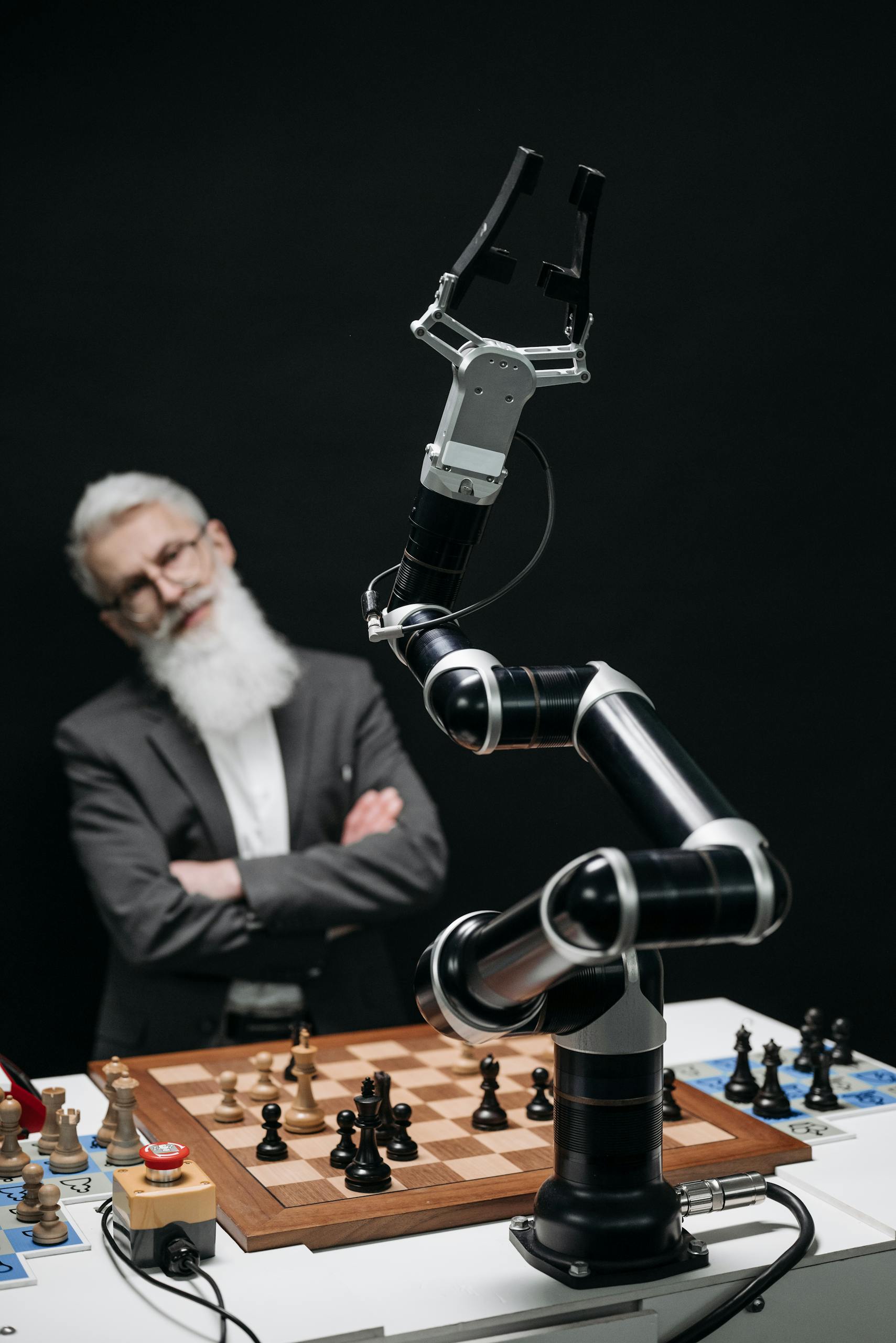 A robotic arm versus a thoughtful man in a strategic chess game indoors.