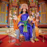 woman in purple and gold sari sitting on chair