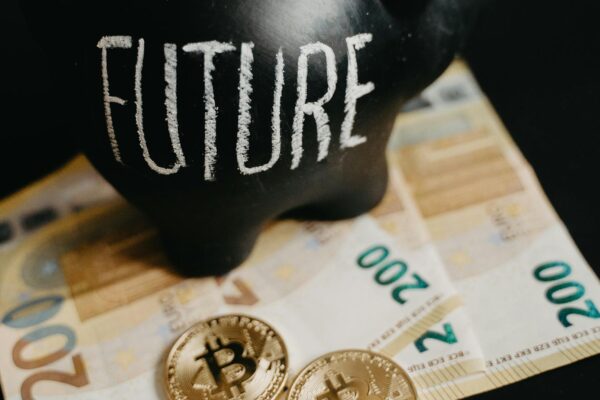 Black piggy bank labeled 'Future' with 200 euro bills and Bitcoin coins, symbolizing modern savings.