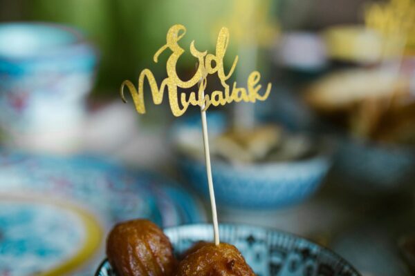 Charming Eid Mubarak scene with traditional sweets in a ceramic bowl, perfect for festive occasions.