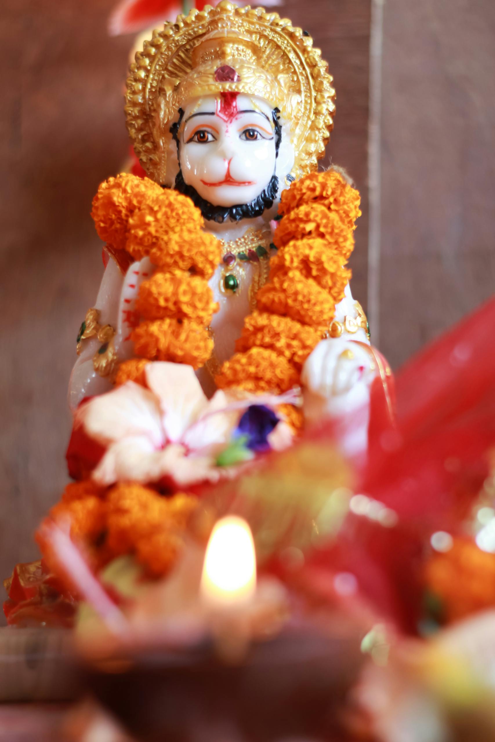 Close-up of a sacred Hanuman statue adorned with garlands, capturing spiritual essence.