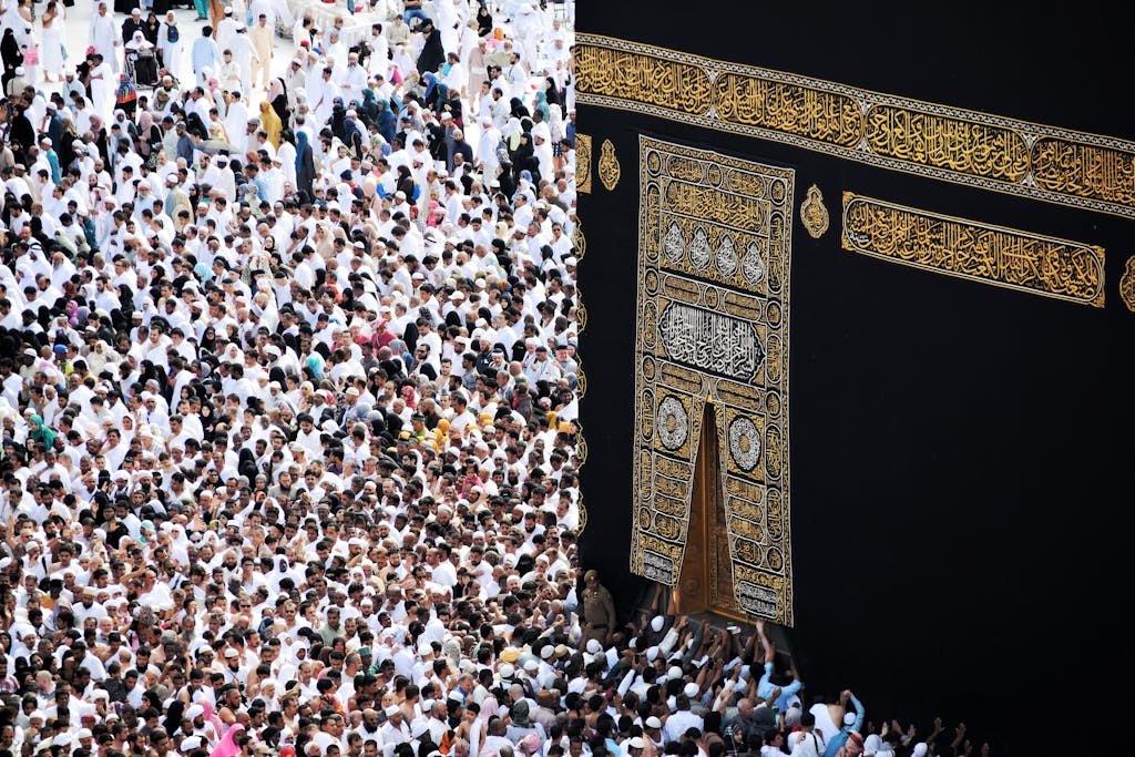 Mass of pilgrims in traditional attire at Kaaba during the Hajj pilgrimage.